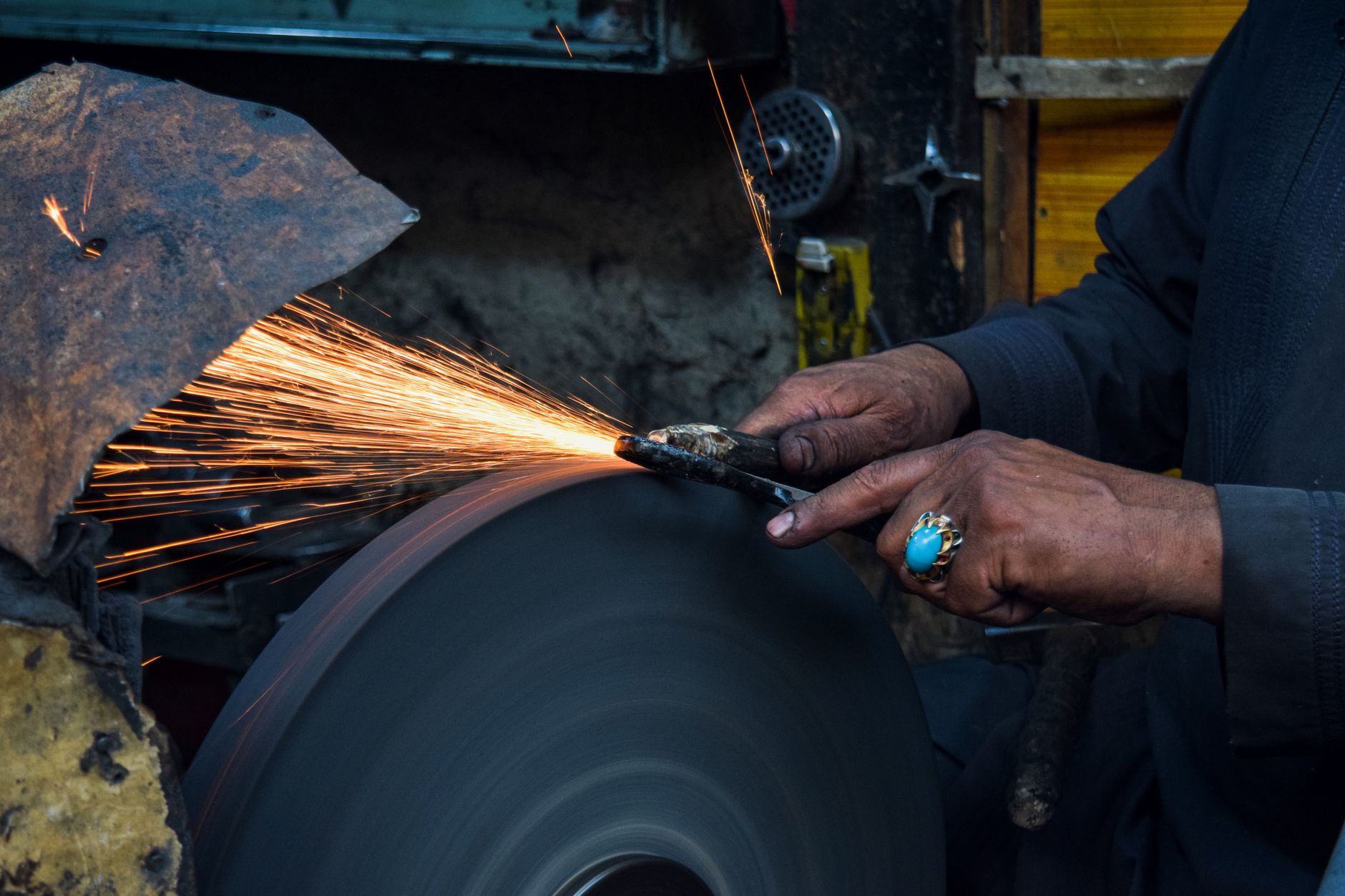 close up of a man using a grinder in a workshop