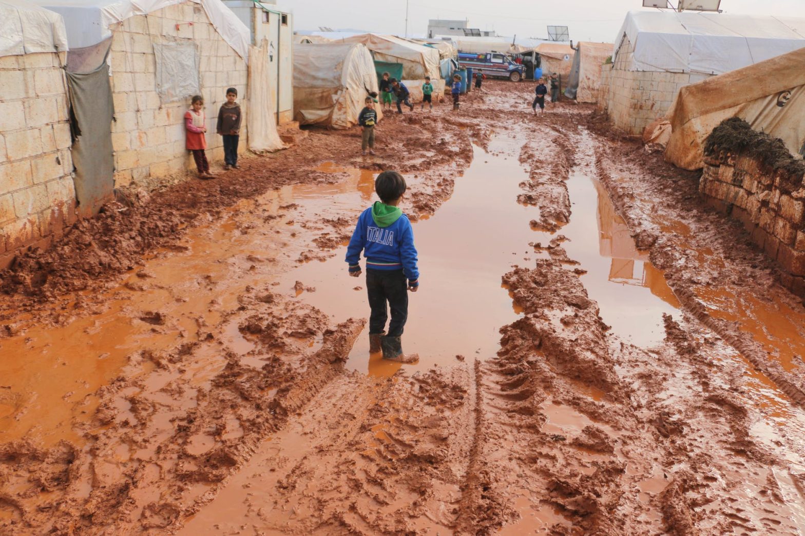 refugee kids on dirty ground
